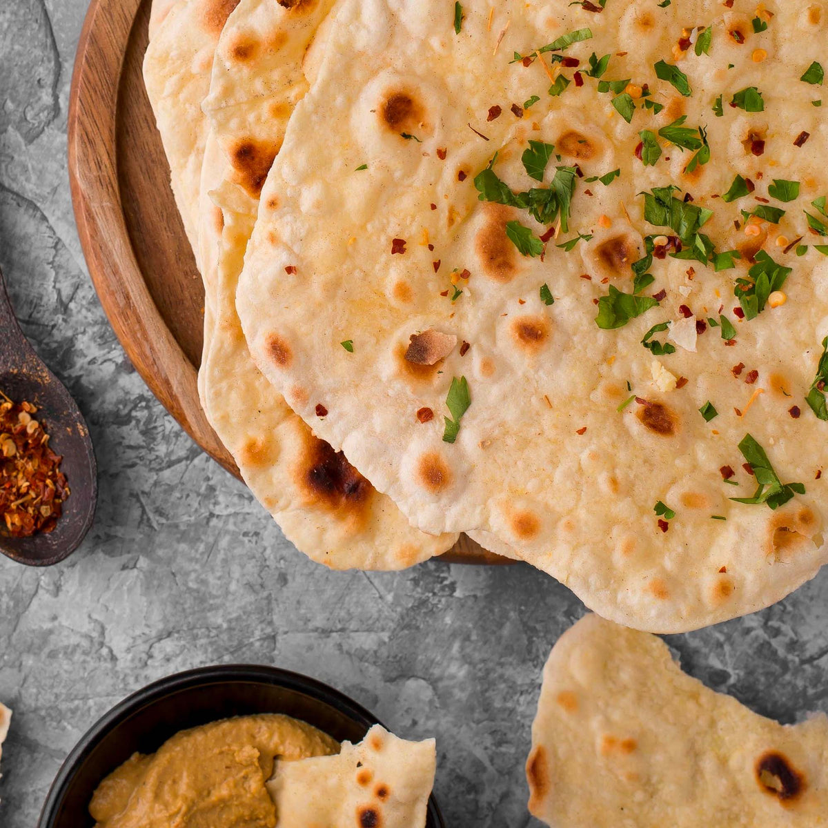 Piadine di chufa dorate con erbe aromatiche, accompagnati da una crema in ciotola.